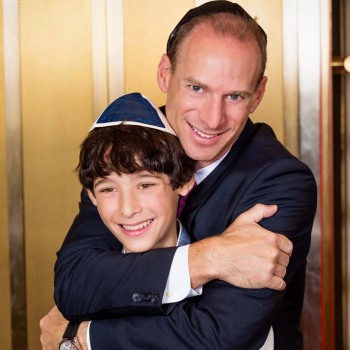 Proud father hugs son at bar mitzvah