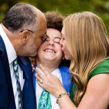 Bar mitzvah boy smothered in parental kisses