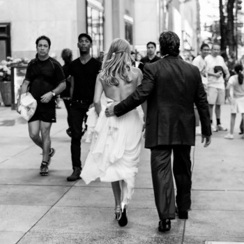 Bride and groom walk up Fifth Avenue in NYC