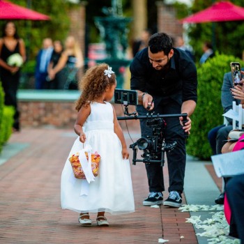 Videographer surprises flower girl on wedding aisle
