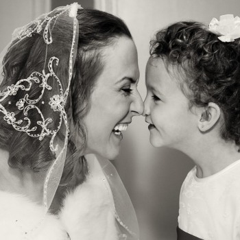Bride nuzzles the flower girl in private moment