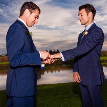 Grooms exchange wedding rings