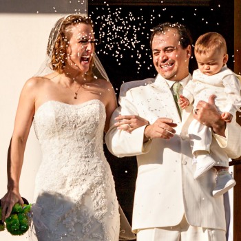 Happy newlyweds exiting chapel as rice is thrown