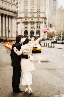 bride and groom hailing a taxi