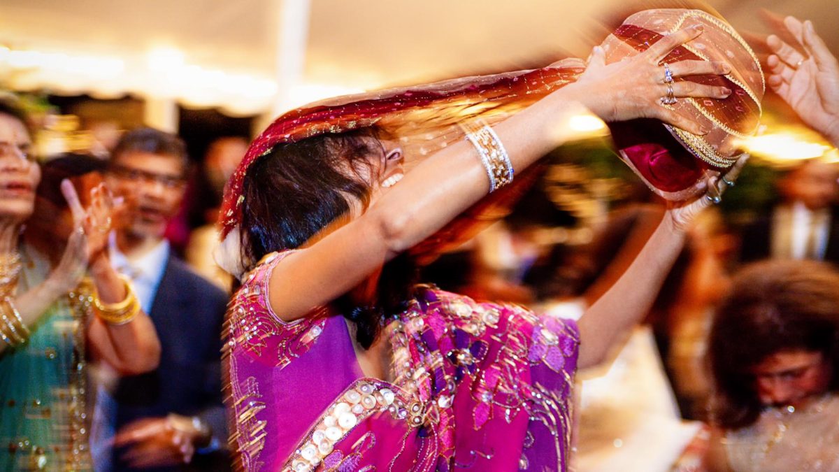 Photo of a bride dancing in her sari